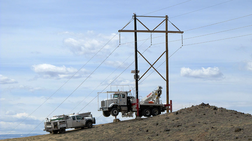 An industrial work truck beneath a transmission line