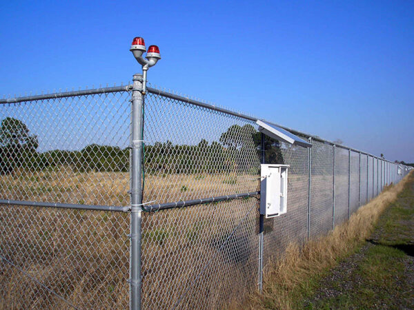 SunPOWR AIO solar obstruction light mounted to corner of a fence.