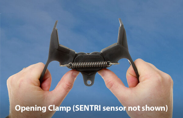 Photo showing a person opening a SENTRI clamp with their hands.