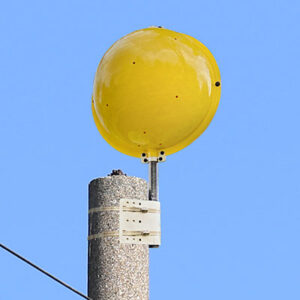 Crossover marker shown at the top of a power line pole.