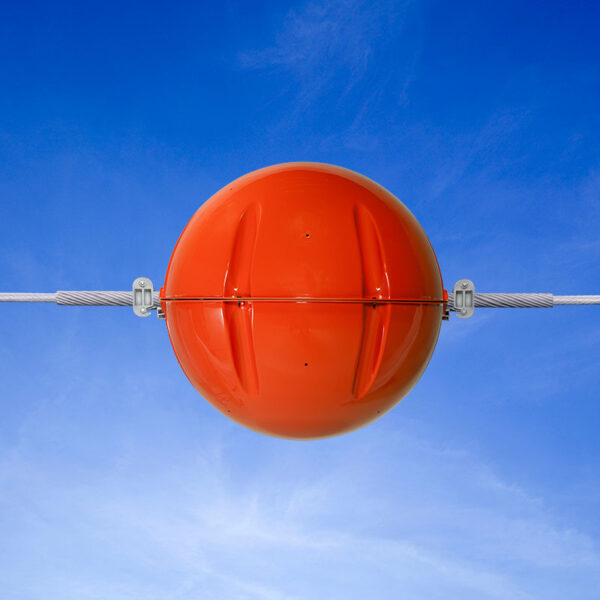 PRM-36 power line marker shown installed on a power line against a blue sky background.